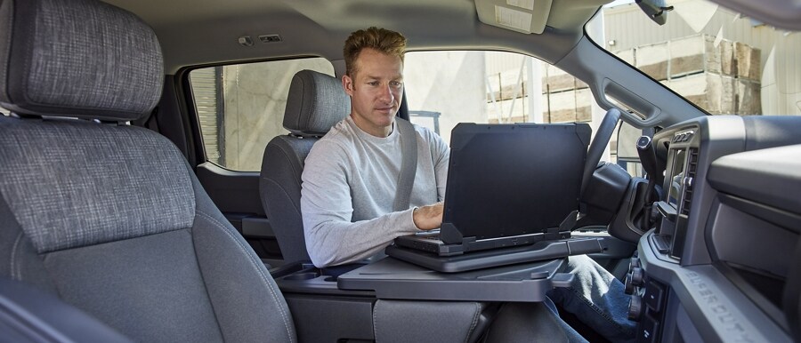 Person working on a laptop computer inside a 2023 Ford Super Duty® F-250® XL pickup