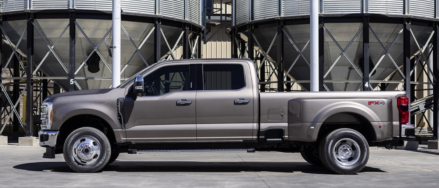 Una Ford Super Duty® F-350® LARIAT 2023 estacionada cerca de un silo de granos