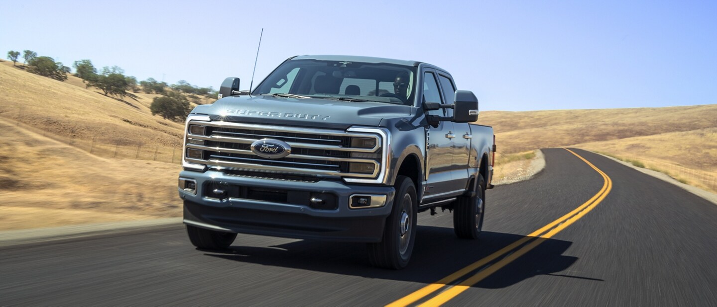 Una Ford Super Duty® F-350® Limited 2023 circulando cerca de un campo