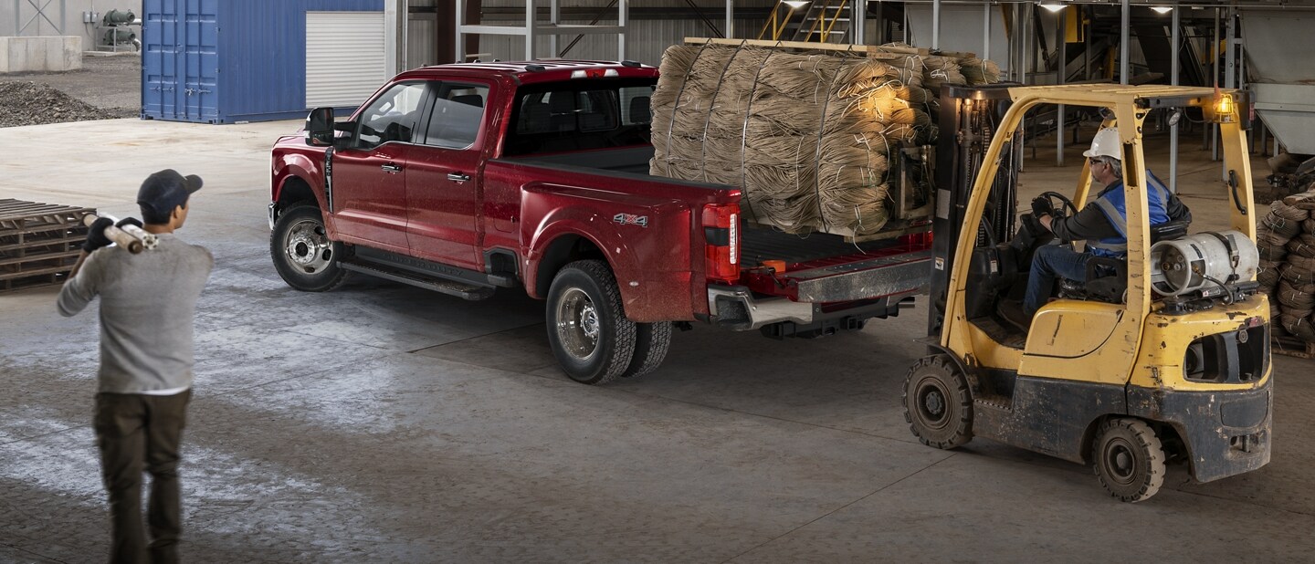 Hi-low loading a pallet full of bags of grain into the bed of 2023 Ford Super Duty® LARIAT Crew Cab