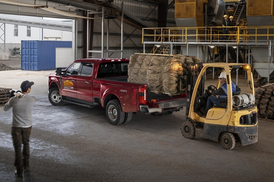 Una Ford Super Duty® F-350® LARIAT 2023 cargada con una tarima de pacas de heno