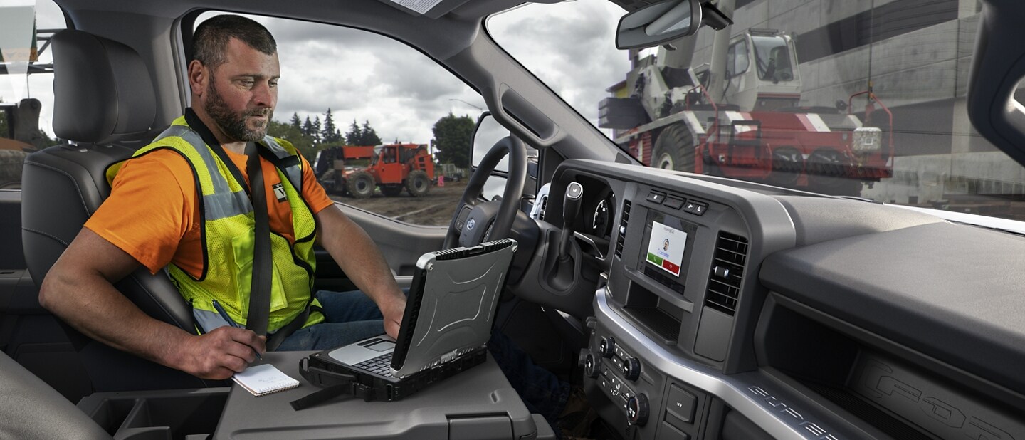 Man working on laptop inside a 2023 Ford Super Duty® F-250® XL pickup