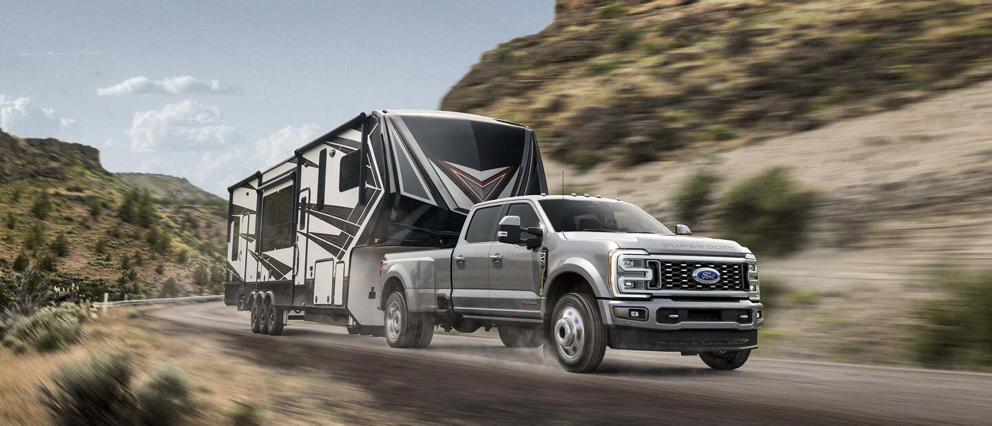 Una Ford Super Duty® F-450® Limited 2023 remolcando una casa rodante en una carretera pintoresca