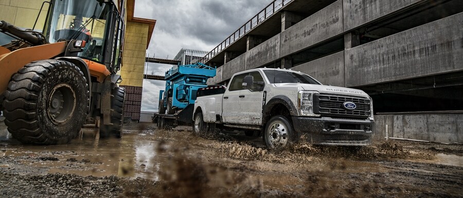 Una Ford Super Duty® F-350® LARIAT 2023 empujando una caravana en una carretera pintoresca