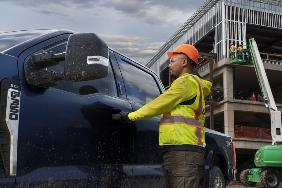 Trabajador de la construcción abriendo la puerta de una Ford Super Duty® F-350® 2023 con XLT