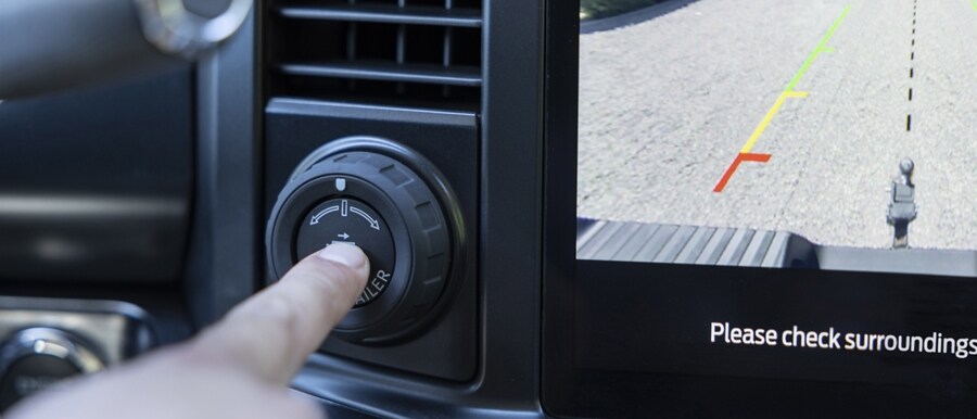 Close-up of a person pushing the pro trailer hitch assist button in a 2023 Ford Super Duty® pickup