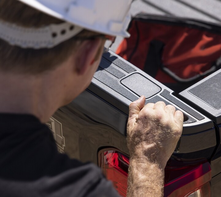 Close-up on a person grasping the truck bed hand pocket