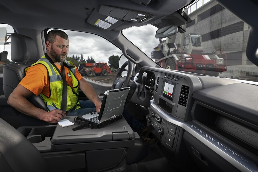 Man working on laptop inside a 2024 Ford Super Duty® F-250® XL pickup