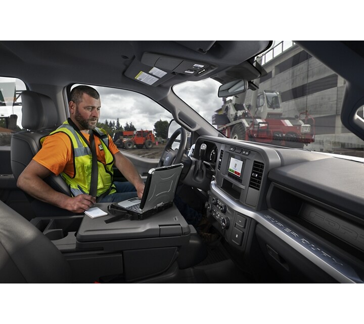 Man working on a laptop computer inside a Ford Super Duty® pickup