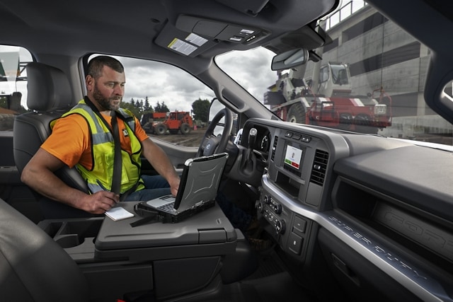 Man working on laptop inside a 2024 Ford Super Duty® F-250® XL pickup