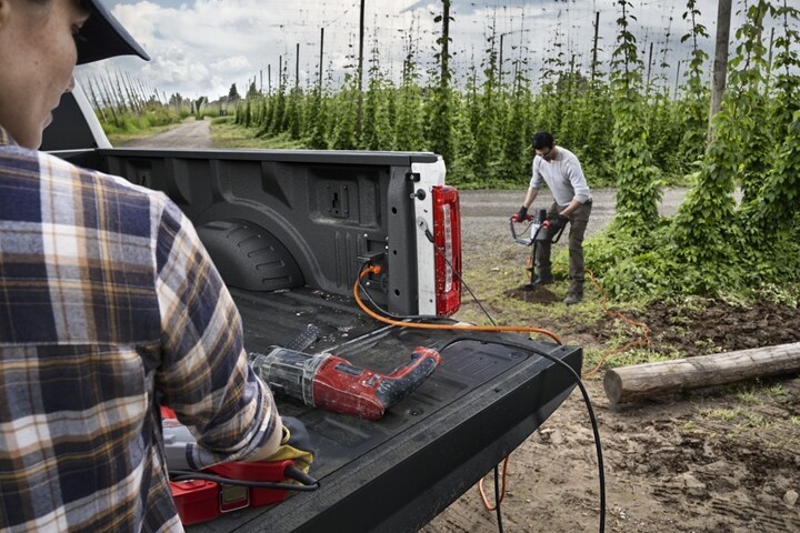 Two workers using the Pro Power Onboard feature on a 2024 Ford Super Duty® pickup