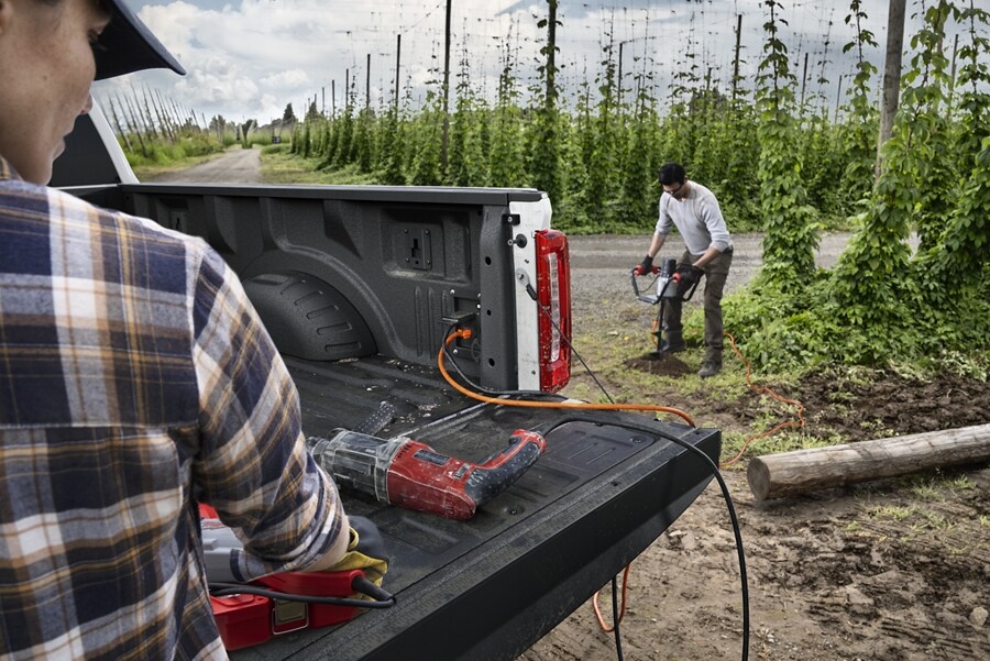 Two people using the Pro Power Onboard feature on a 2024 Ford Super Duty® pickup