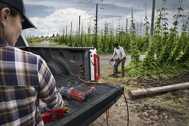 Two people using the Pro Power Onboard feature on a 2024 Ford Super Duty® pickup