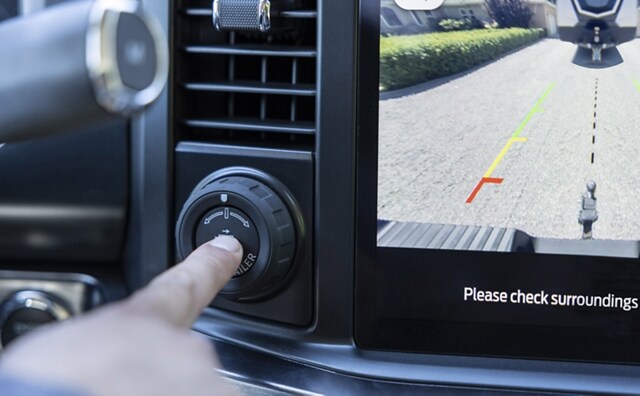 Close-up of a person pushing the pro trailer hitch assist button in a 2024 Ford Super Duty® pickup