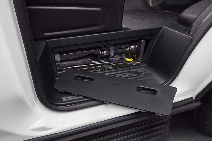 A close-up of the open tire jack compartment on a 2023 Ford Transit®