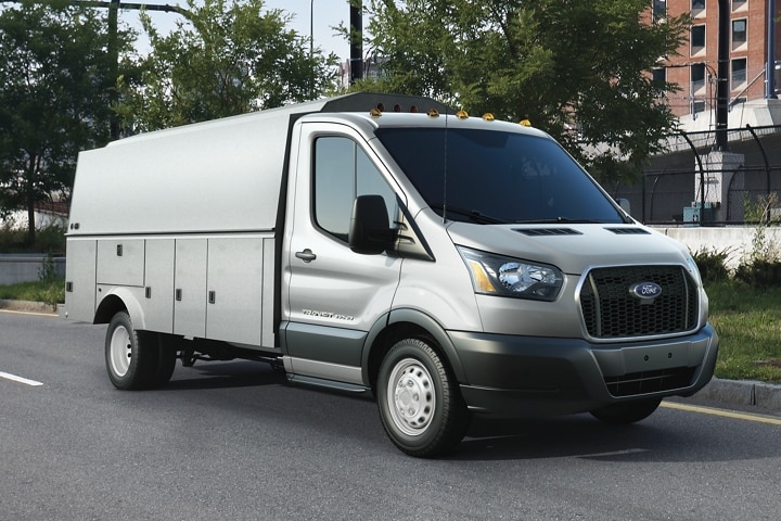 A 2023 Ford Transit® being driven down a road in an urban setting