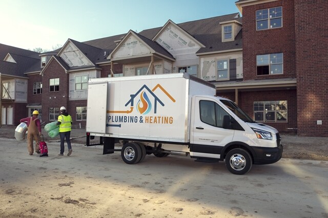 A 2023 Ford Transit® Chassis Cab parked at a job site with two workers approaching
