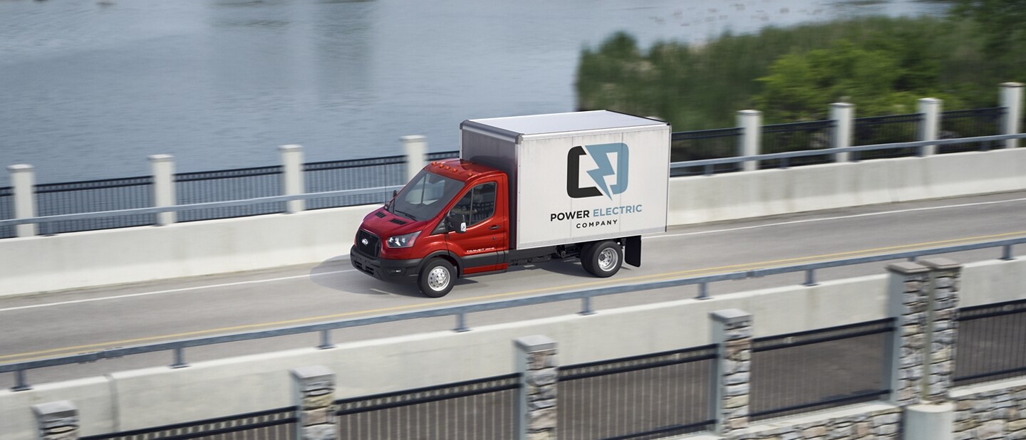 Side view of a 2023 Ford Transit® Chassis Cab being driven on a freeway bridge