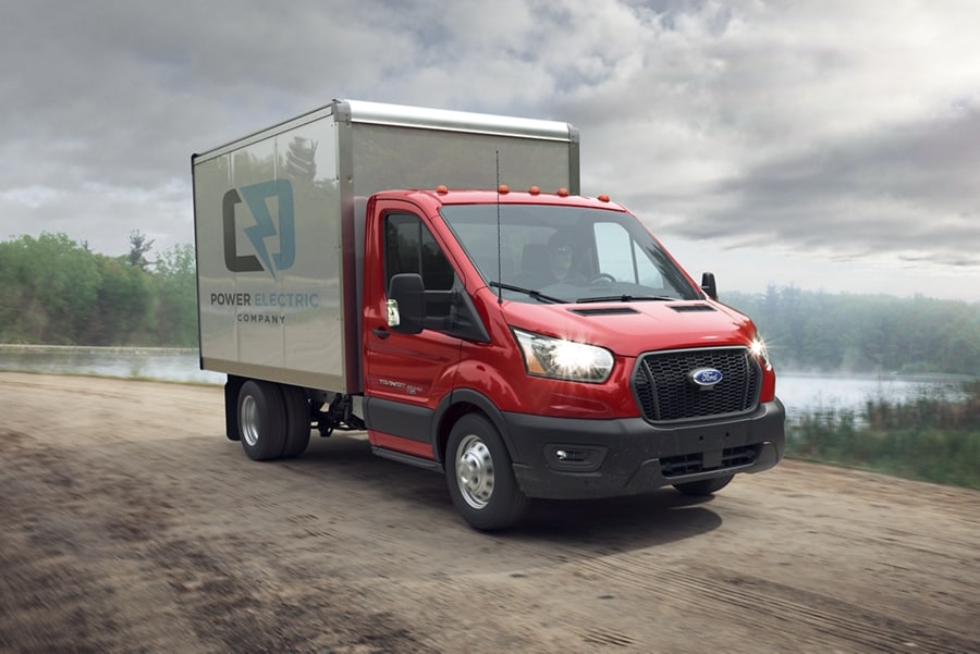 A 2023 Ford Transit® Chassis Cab on a dirt road near a lake