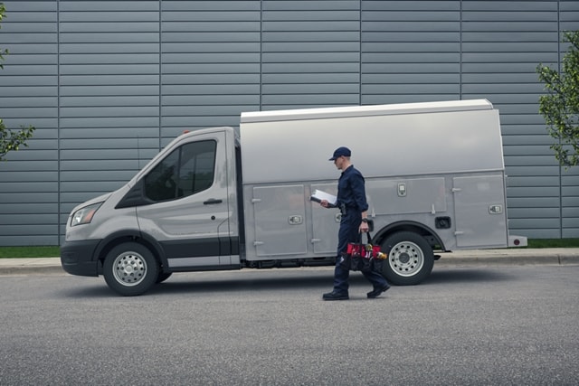 A person approaching a 2023 Ford Transit® Chassis Cab in Avalanche Gray