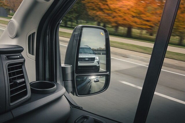 Primer plano del espejo lateral de una Ford Transit® 2023 que muestra la Asistencia de Punto Ciego 1.0
