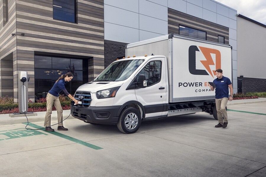 Una Ford Transit® 2023 estacionada en un sitio de construcción y una persona con un sujetapapeles