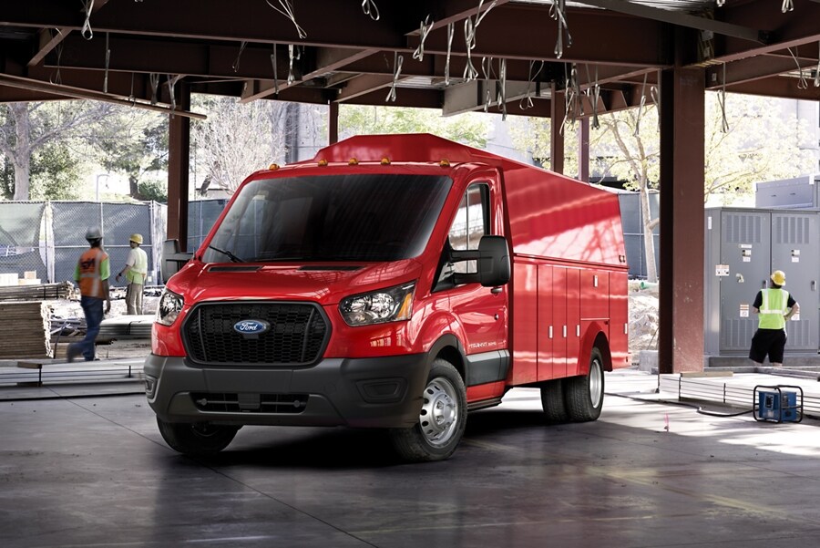 A 2023 Ford Transit® Red Chassis Cab Cutaway parked at a construction site