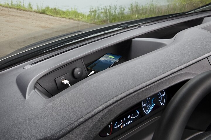 A close up of a phone charging on the front dash USB port