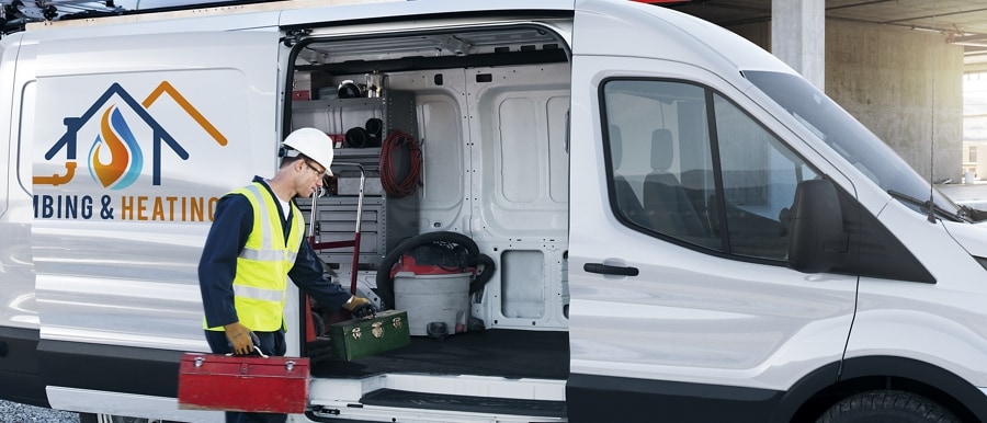 A man grabbing equipment out of the side door of a 2023 Ford Transit® van