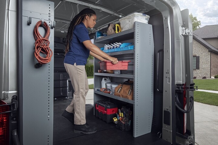 A person in the back of a 2023 Ford Transit® van with open cargo doors