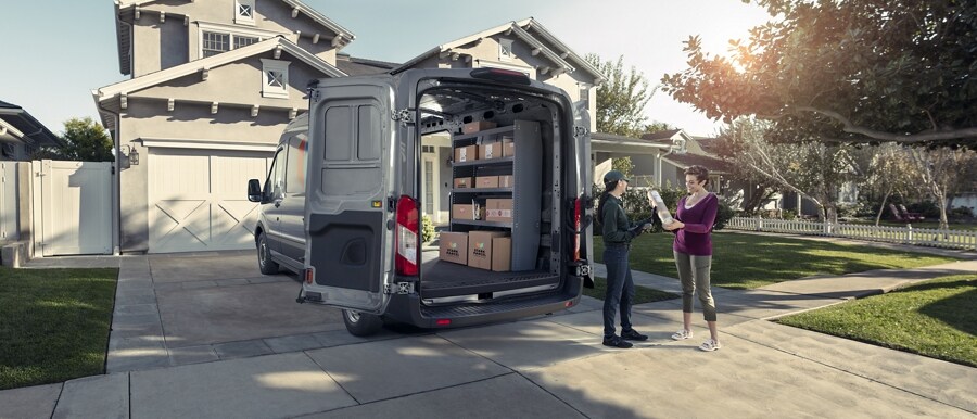 Two women standing next to a 2023 Ford Transit® van with its rear doors open