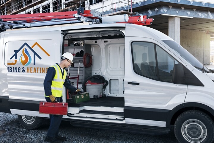 A worker loading equipment into a parked Transit® Cargo van
