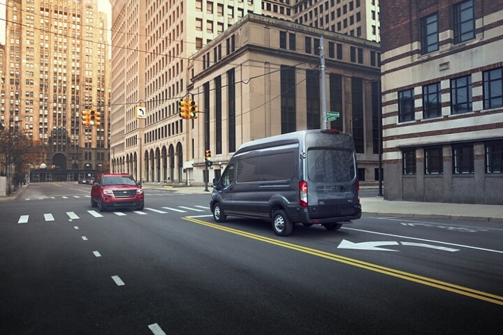 Vista trasera de una Ford Transit® Cargo Van 2023 estacionada en la calle de una ciudad