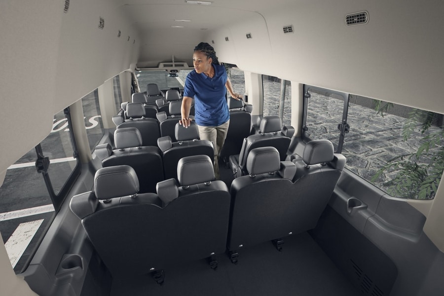 Women walking through the interior of a 2024 Ford Transit® van with 15-passenger seating