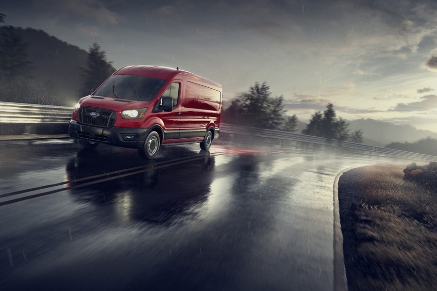 A 2024 Ford Transit® van being driven down a wet road