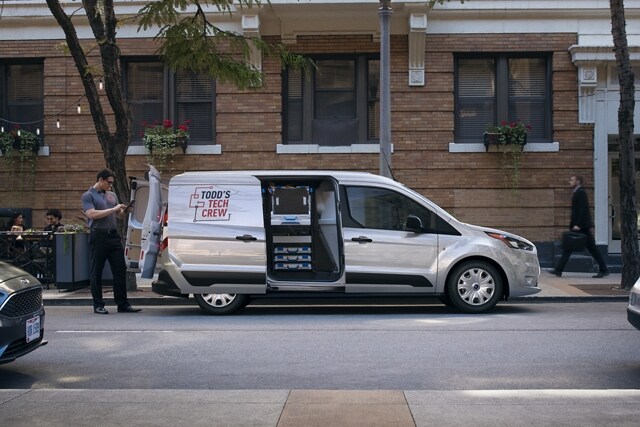 2023 Ford Transit Connect Cargo Van parked in the city shown with available rear swing-out doors and sliding side door open