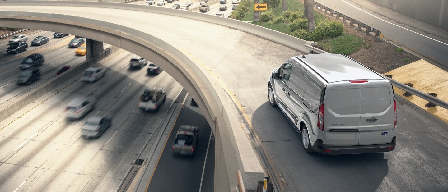 Ford Transit Connect Cargo Van 2023 en Silver andando por la curva de una autopista