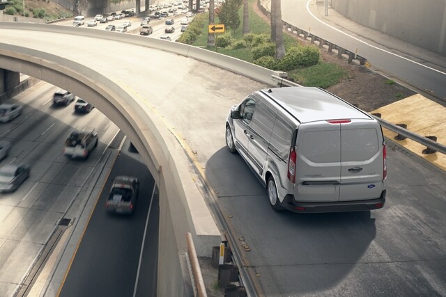2023 Ford Transit Connect Cargo Van in Silver being driven on an expressway ramp