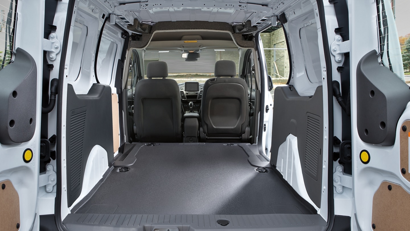 Interior de una Ford Transit Connect Cargo Van 2023 que muestra gran ancho de cavidad en las ruedas