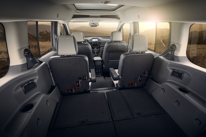 Vista interior de un Wagon para Pasajeros Ford Transit Connect 2023 mostrando los asientos plegables en la segunda y tercera filas