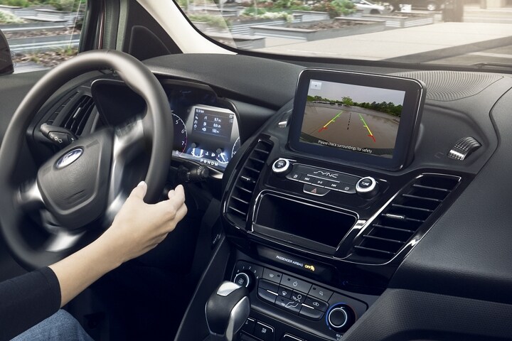 Vista interior de una Wagon para Pasajeros Ford Transit Connect 2023 mostrando la pantalla de la Cámara de Marcha Atrás en la pantalla disponible.