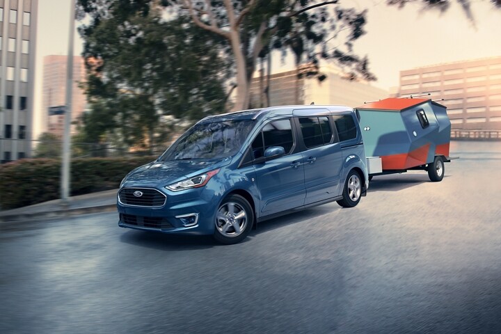 Un Wagon para Pasajeros Ford Transit Connect 2023 remolcando un tráiler en la ciudad