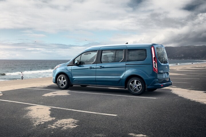 Se muestra un Wagon para Pasajeros Ford Transit Connect 2023 en Blue estacionado junto a la playa