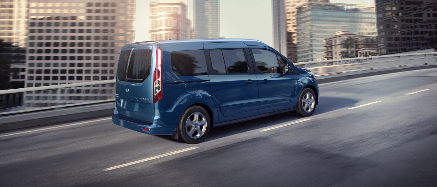 2023 Ford Transit Connect Passenger Wagon in Blue being driven on a city road.