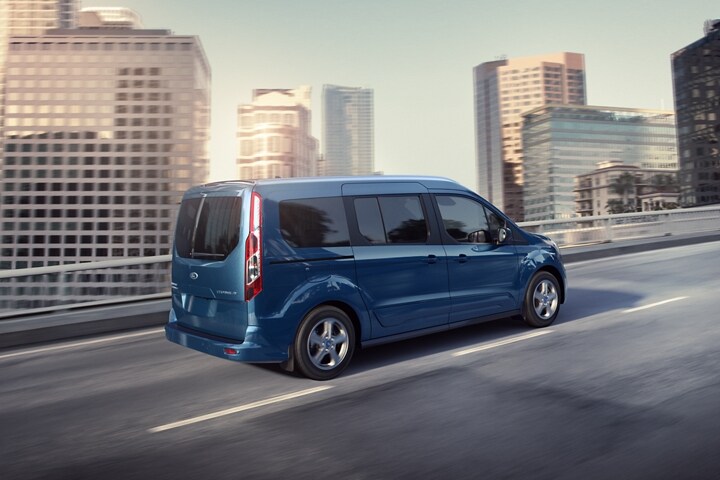 Un Wagon para Pasajeros Ford Transit Connect 2023 en Blue andando por la carretera de una ciudad
