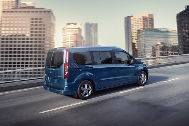 2023 Ford Transit Connect Passenger Wagon in Blue being driven on a city road.