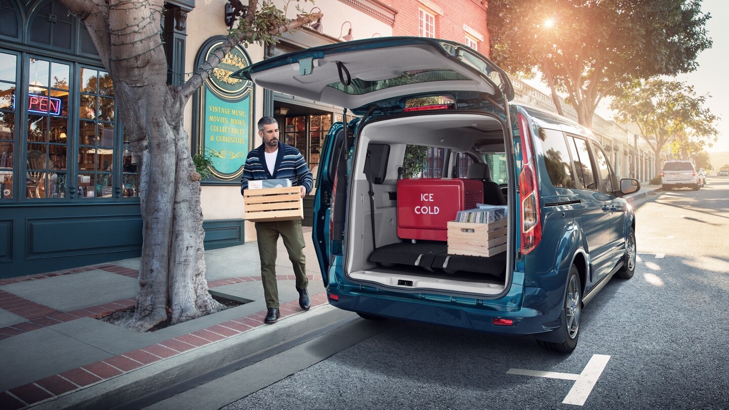 Man using the available rear liftgate on 2023 Ford Transit Connect Passenger Wagon parked on a street