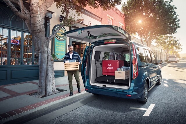 Man loading up a 2023 Ford Transit Connect Passenger Wagon through the rear door