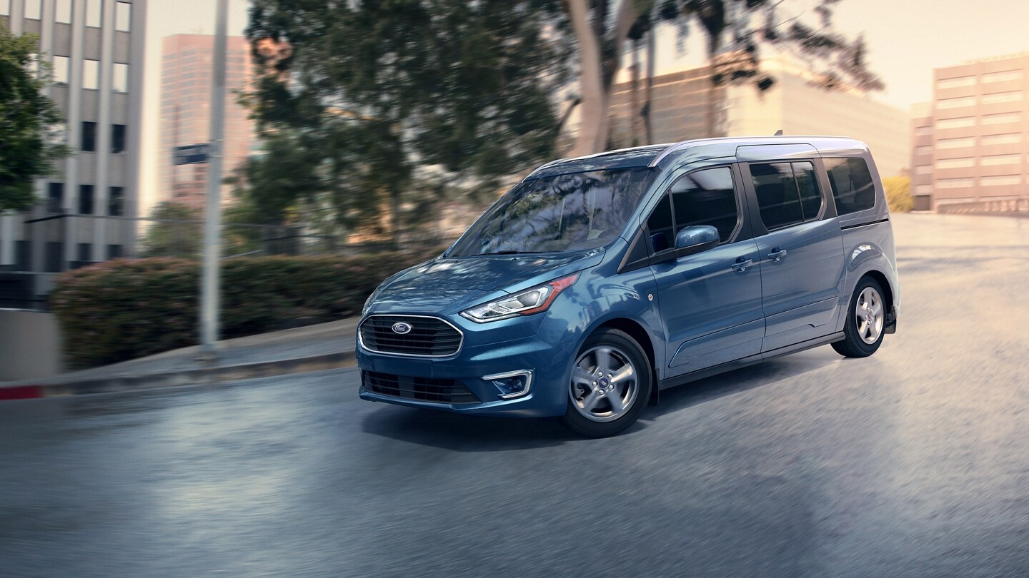 Wagon para Pasajeros Ford Transit Connect 2023 en Blue Metallic andando por una calle urbana