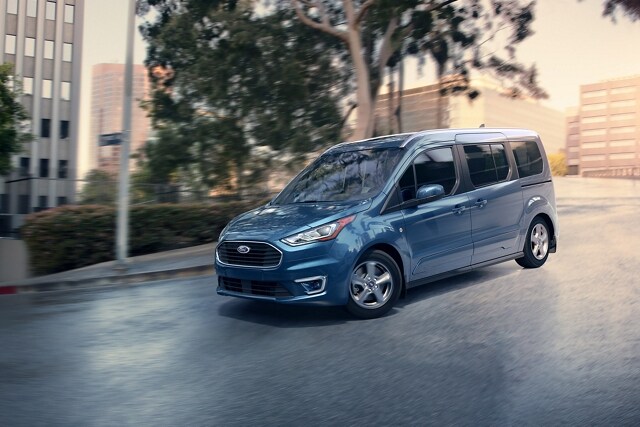 Blue Metallic 2023 Ford Transit Connect Passenger Wagon being driven on a city street